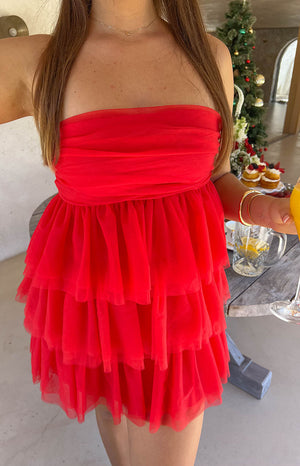 Close-up of the red strapless mini dress showing the ruched bodice and tiered ruffled tulle skirt