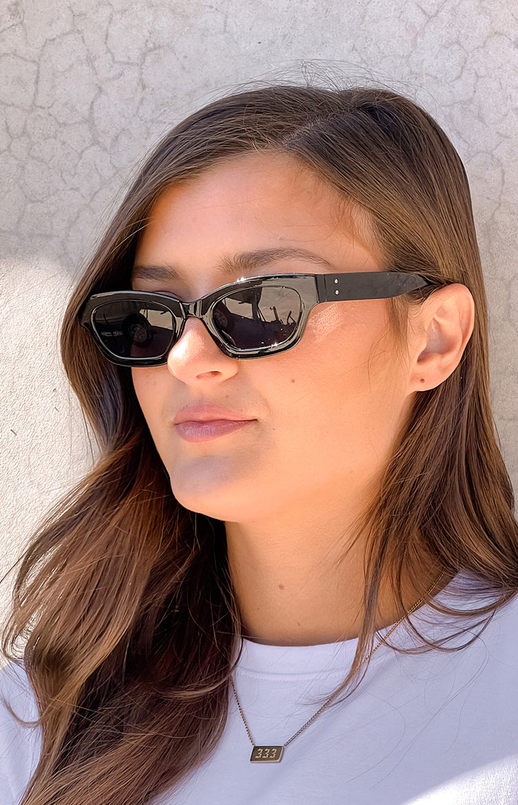 Beginning Boutique Black Slimline Sunglasses black slimline sunglasses with a subtle cat-eye shape and dark lenses