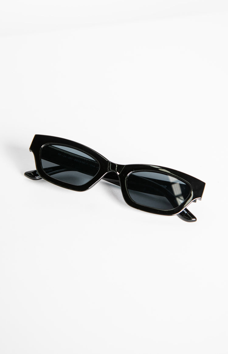 Angled view of black slimline sunglasses with dark rectangular lenses and subtle upturned outer corners