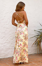 Rear view of a yellow floral satin maxi dress with criss-cross tie-back spaghetti straps and ruched detail