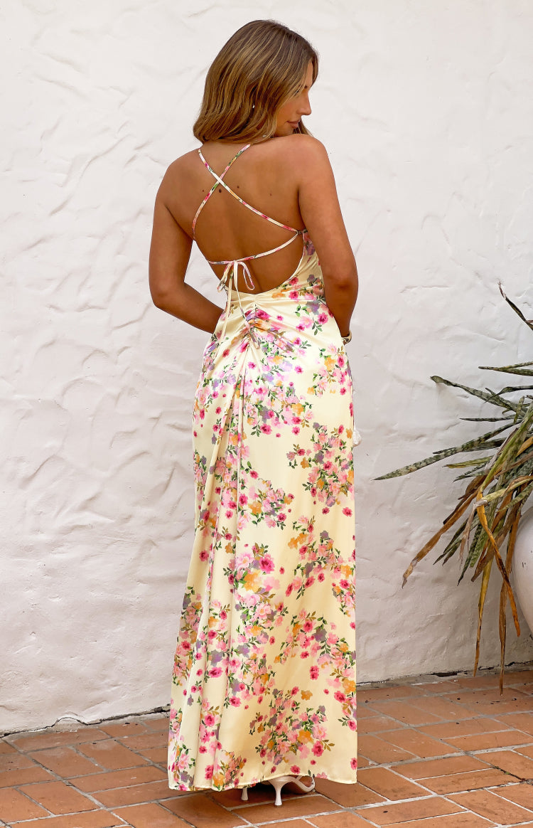 Rear view of a yellow floral satin maxi dress with criss-cross tie-back spaghetti straps and ruched detail