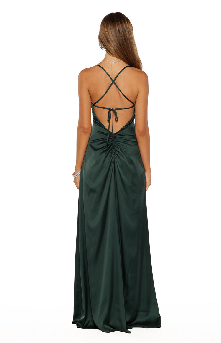 Rear view of an emerald satin maxi dress with criss-cross spaghetti straps, tie-back, and ruched detail on the lower back