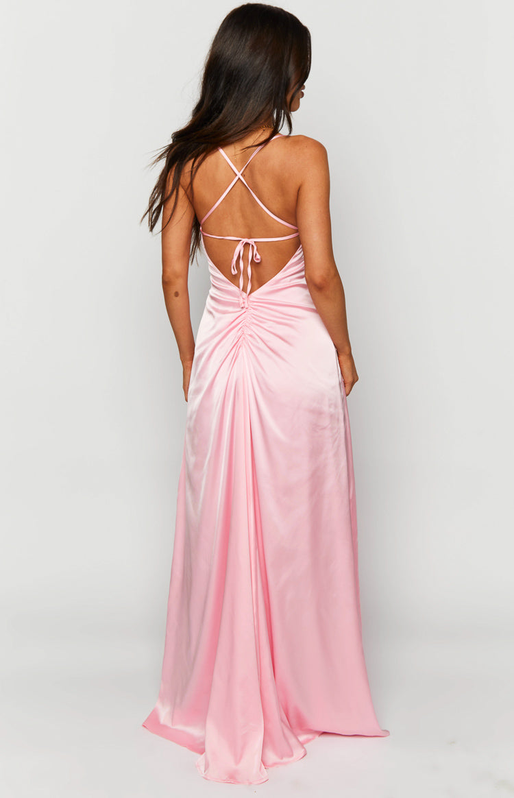 Back view of a pink satin maxi dress with thin criss-cross straps, a tie-back, and ruched lower back