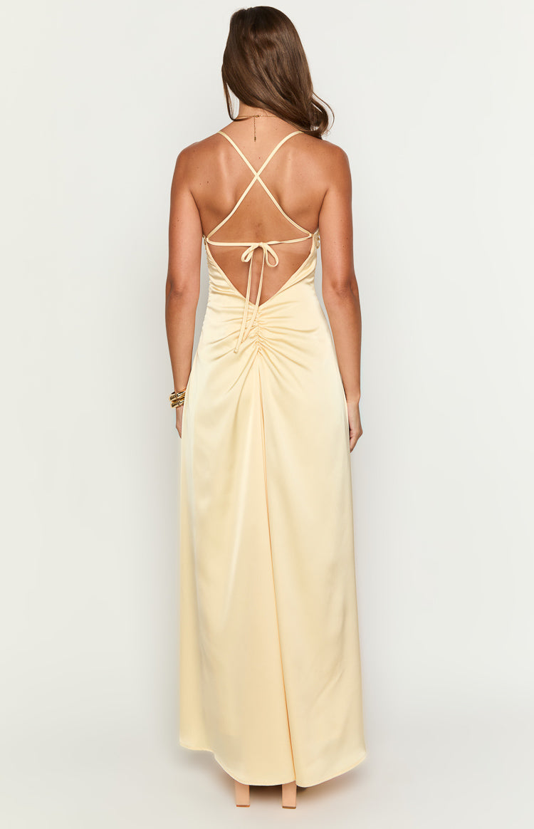 Rear view of a yellow satin maxi dress showing criss-cross spaghetti straps, a tie-back, and ruched detail on the lower back