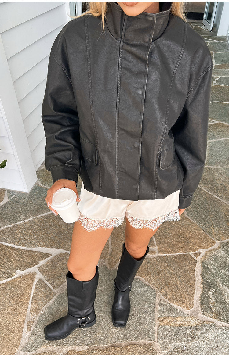 Front view of a black PU jacket showing the funnel neck, button-front, and flap pockets