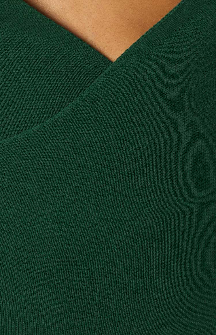 Side view showing the open back with thin criss-cross tie straps and the fitted emerald midi dress