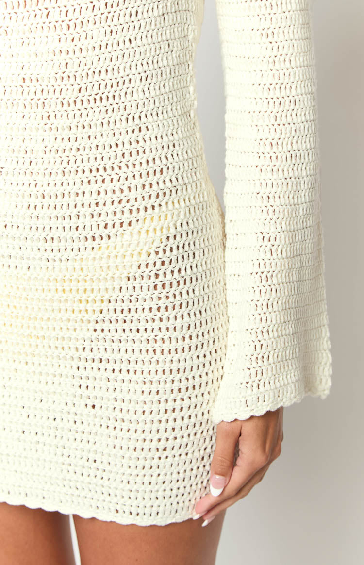 Fitted white crochet mini dress with a square neckline, long bell sleeves, and scalloped edges