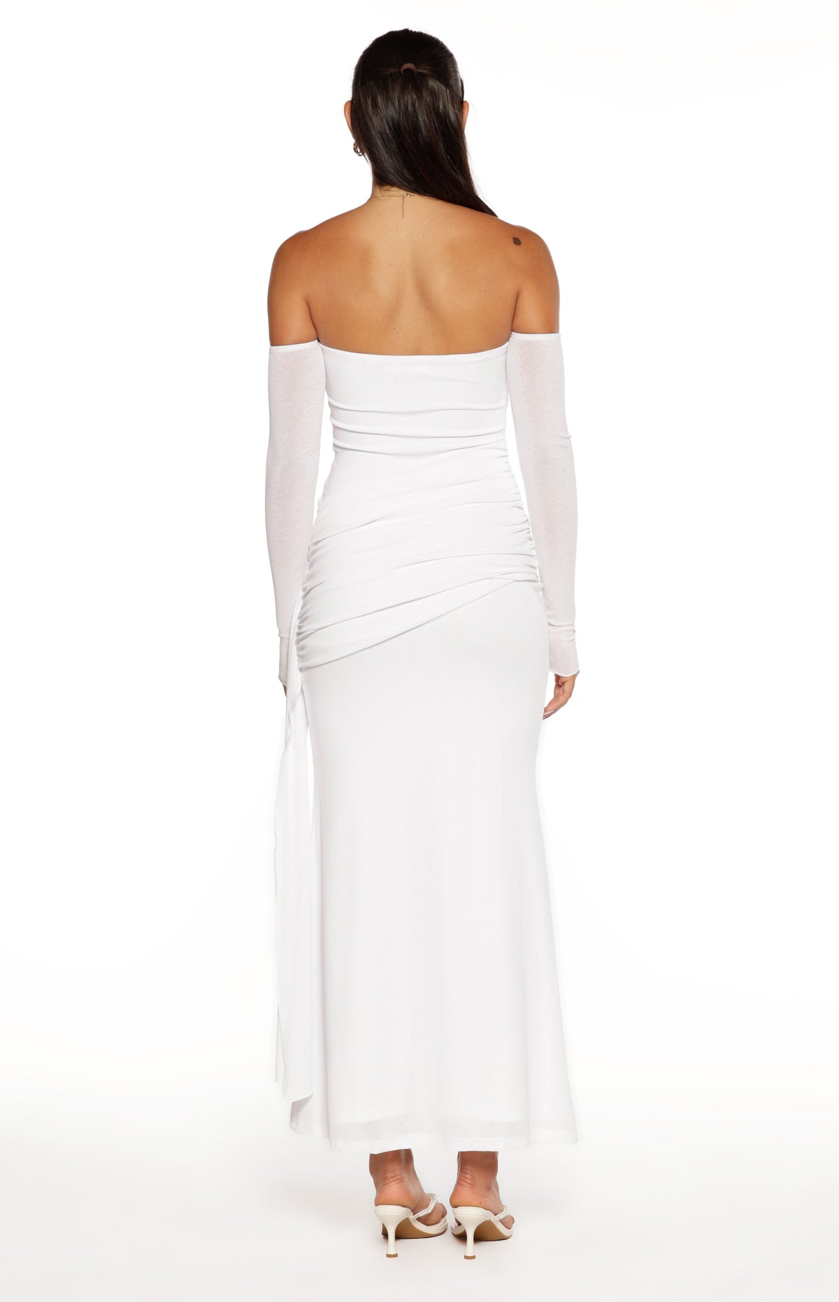Rear view of a white strapless maxi dress with long sheer sleeves and ruched detailing on the back
