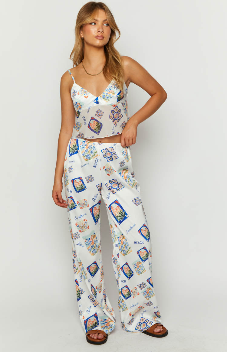 White satin wide-leg pants with a colourful Italia print featuring blue and orange squares and patterns