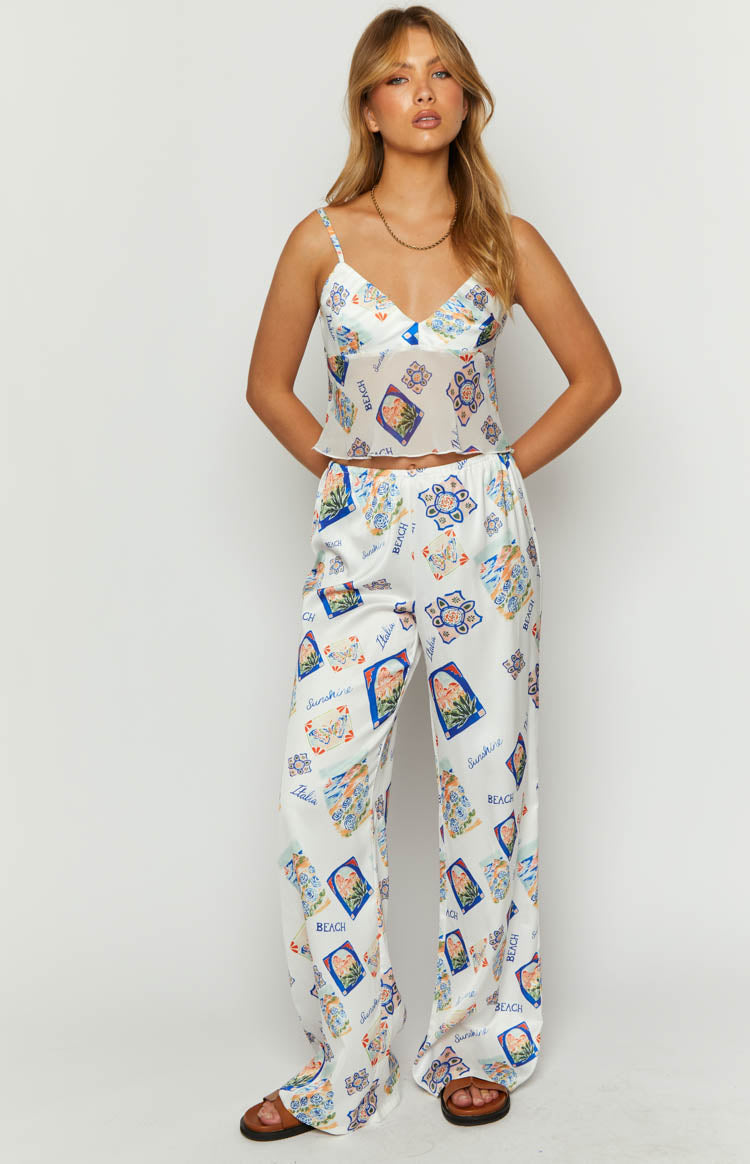 White satin wide-leg pants with a colourful Italia print featuring tiles and scenic motifs