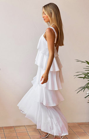 Side view of a white layered frill maxi dress showing the tiered ruffles and flowy skirt