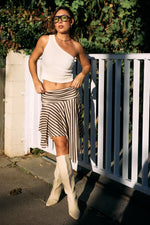 Front view of a brown and beige stripe asymmetrical midi skirt with a flared hem and mixed stripe patterns