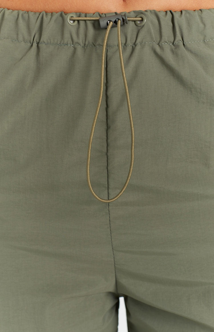 Close-up of the khaki cargo pants elasticated waist with a drawcord and grey toggle