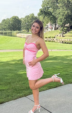 Pink mini dress with a ruched bust, pink flower trim on the sweetheart neckline, and thin spaghetti straps