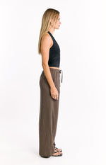 Side view of relaxed brown vertical stripe pants with a drawstring waist