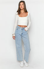 Front view of light wash mid-rise slouchy jeans with wide legs and a relaxed fit
