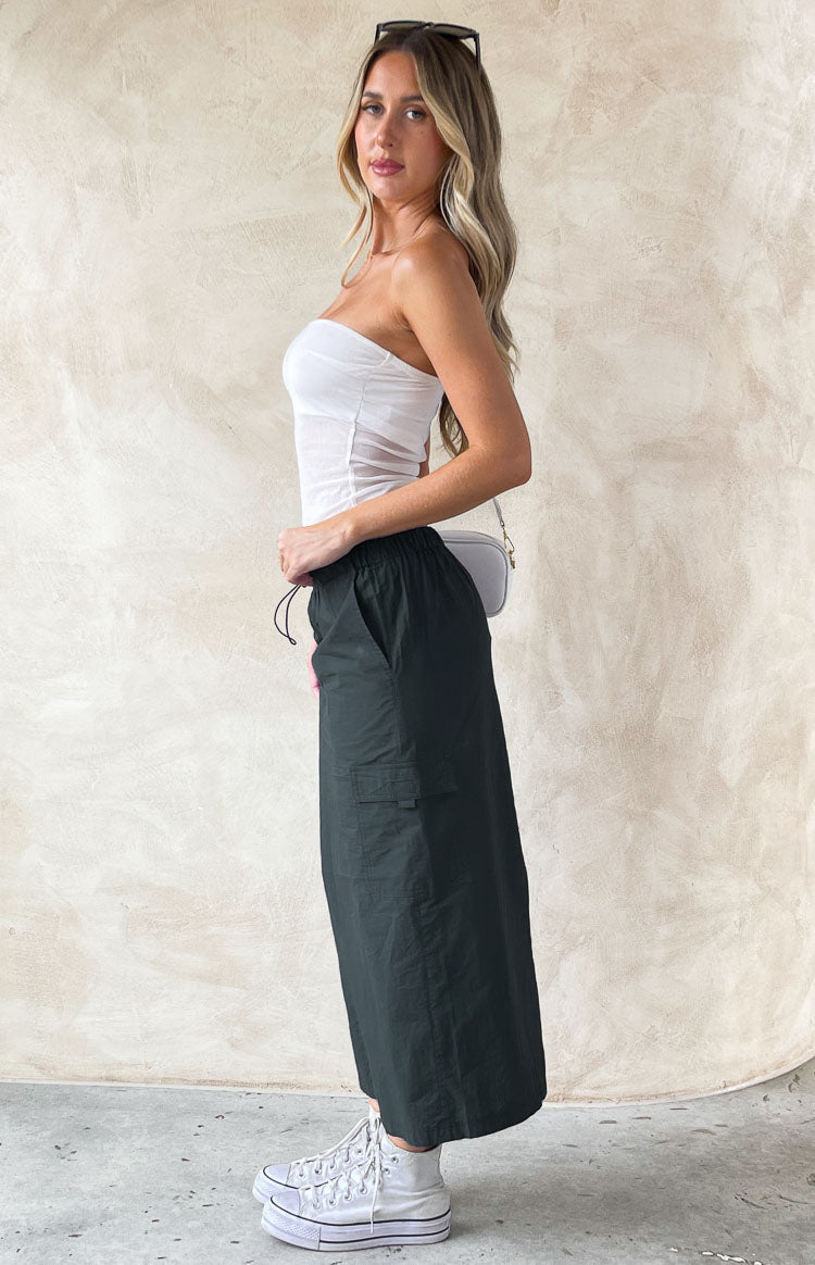 Side view of an indigo midi cargo skirt with an elasticated drawstring waist and side cargo pocket