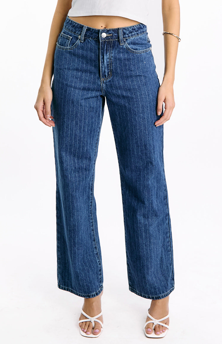 Front view of mid-wash denim jeans with fine white pinstripes, a mid-rise waist, and a slouchy wide-leg cut