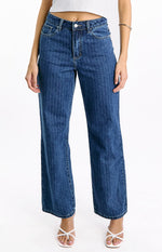Front view of mid-wash denim jeans with fine white pinstripes, a mid-rise waist, and a slouchy wide-leg cut