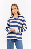 Close-up of a cropped- long-sleeve rugby top with wide cream and blue horizontal stripes and a white collar- with an embroidered logo on the chest- paired with mid-wash- mid-rise slouchy jeans with subtle pinstripes.