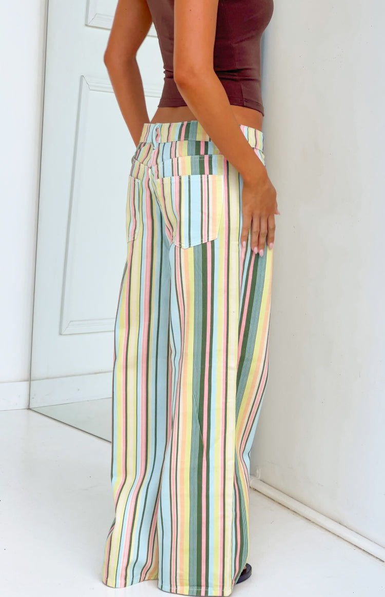 Rear side view of multi stripe low rise jeans with back pockets and pastel blue pink yellow green vertical stripes