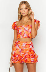 Pink and orange floral print chiffon mini skirt with tiered ruffles and a wrap-style front