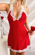 Red polka dot mini dress with white lace trim along the halter neckline and skirt hem