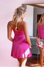 Back view of a hot pink mini dress featuring a shirred bodice and a flowy A-line skirt
