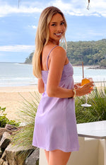 Side view of a lilac mini dress showing the shirred back bodice and flowy skirt