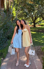 Front view of a light blue mini dress with a square neckline and pleated bodice