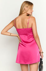 Back view of a hot pink satin mini dress showing the shirred bodice and flowy A-line skirt