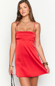 Square neckline and horizontal pleats on the bust of a red satin mini dress with thin straps