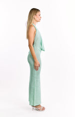Side view of a green textured knit maxi dress with a draped cowl neck and fitted silhouette