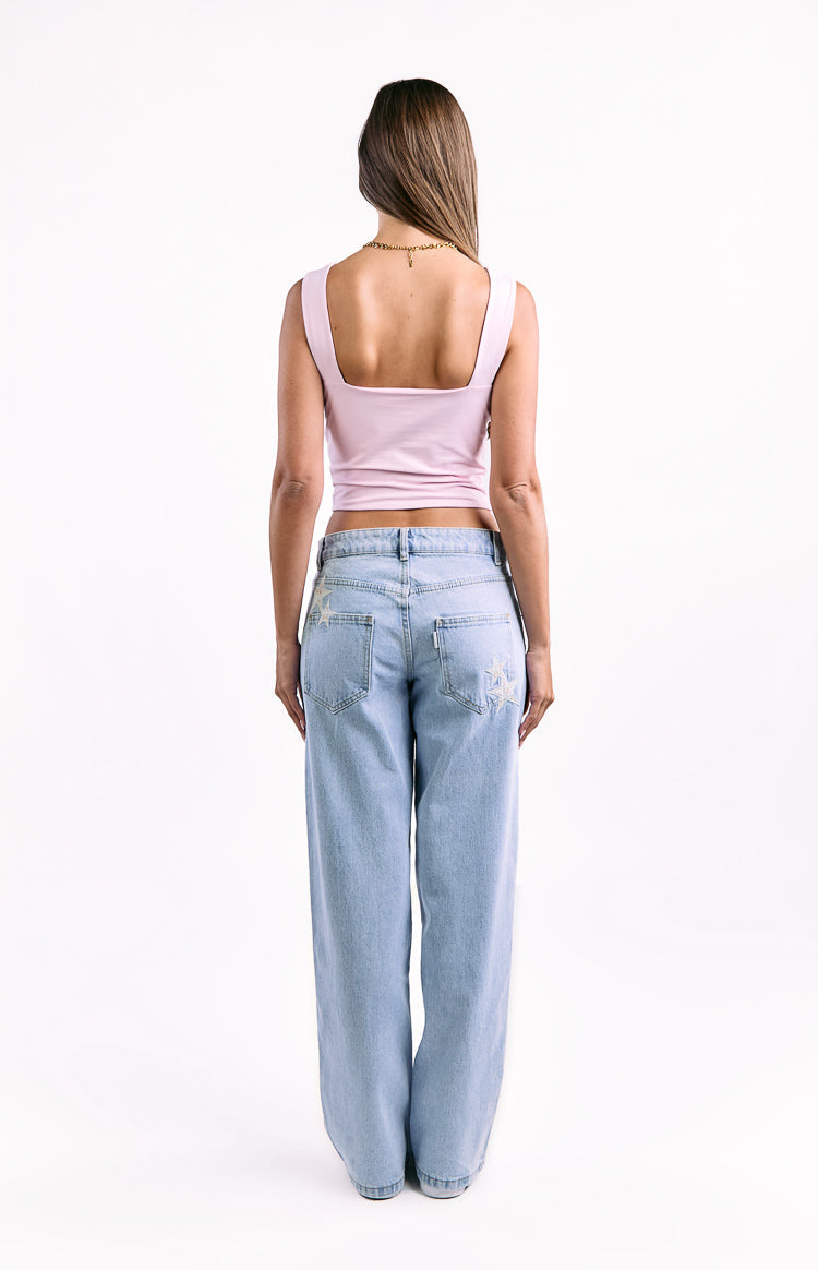 Back view of light wash baggy jeans showing star embroidery on the back pockets and thigh