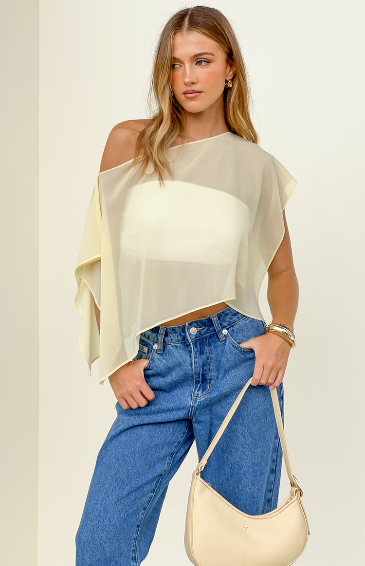 Yellow sheer chiffon cape with an asymmetrical off-shoulder neckline and draped silhouette