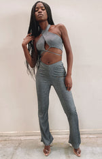 Shimmery grey ribbed knit flared pants with a V-waistband, styled with a matching criss-cross halter crop top