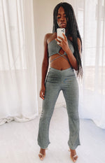 Ribbed dark grey two-piece set with a halter crop top, midriff criss-cross straps, and V-waist flared pants