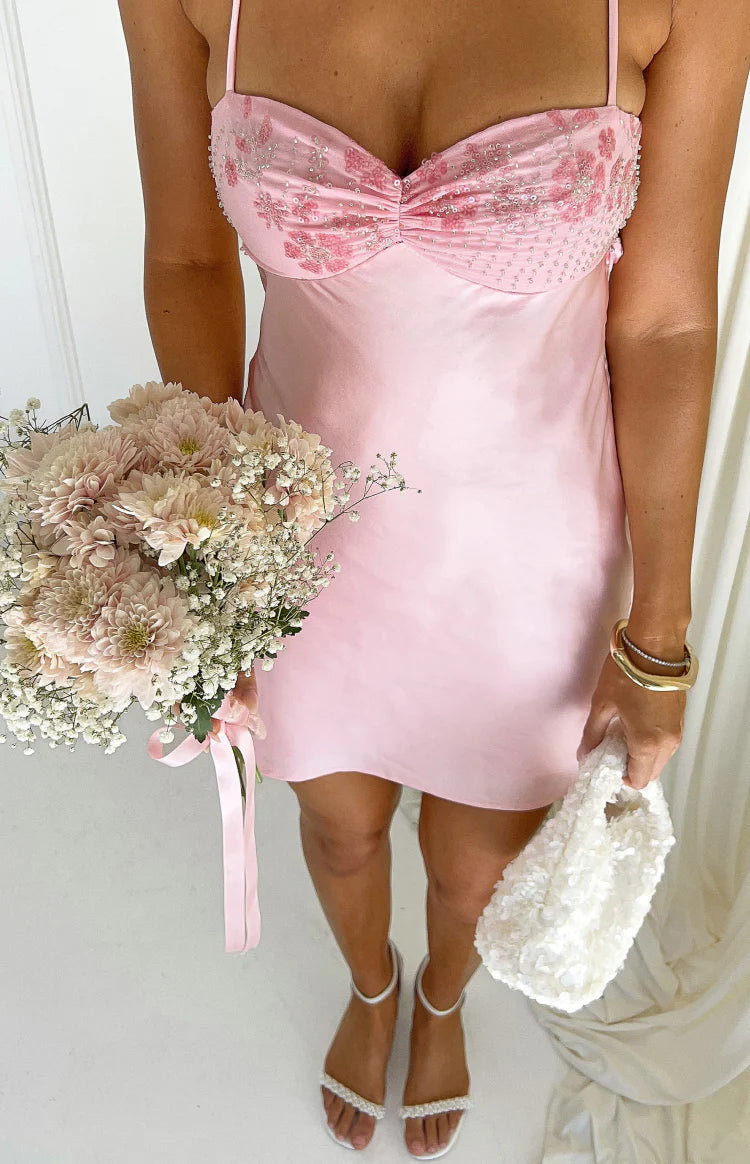 Close-up of the pink satin mini dress with a ruched, beaded floral bust and thin spaghetti straps