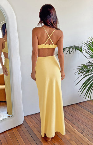 Rear view of a yellow maxi dress with criss-cross spaghetti straps and a ruched elastic back