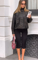 Front view of black jersey capri pants with a fitted silhouette and mid-calf length
