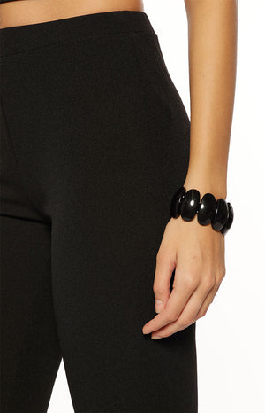 Close-up of the black jersey capri pants fabric, highlighting its soft, fine texture