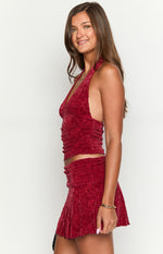 Side view of a red crushed velvet halter crop top with a deep V-neck and ruched side details