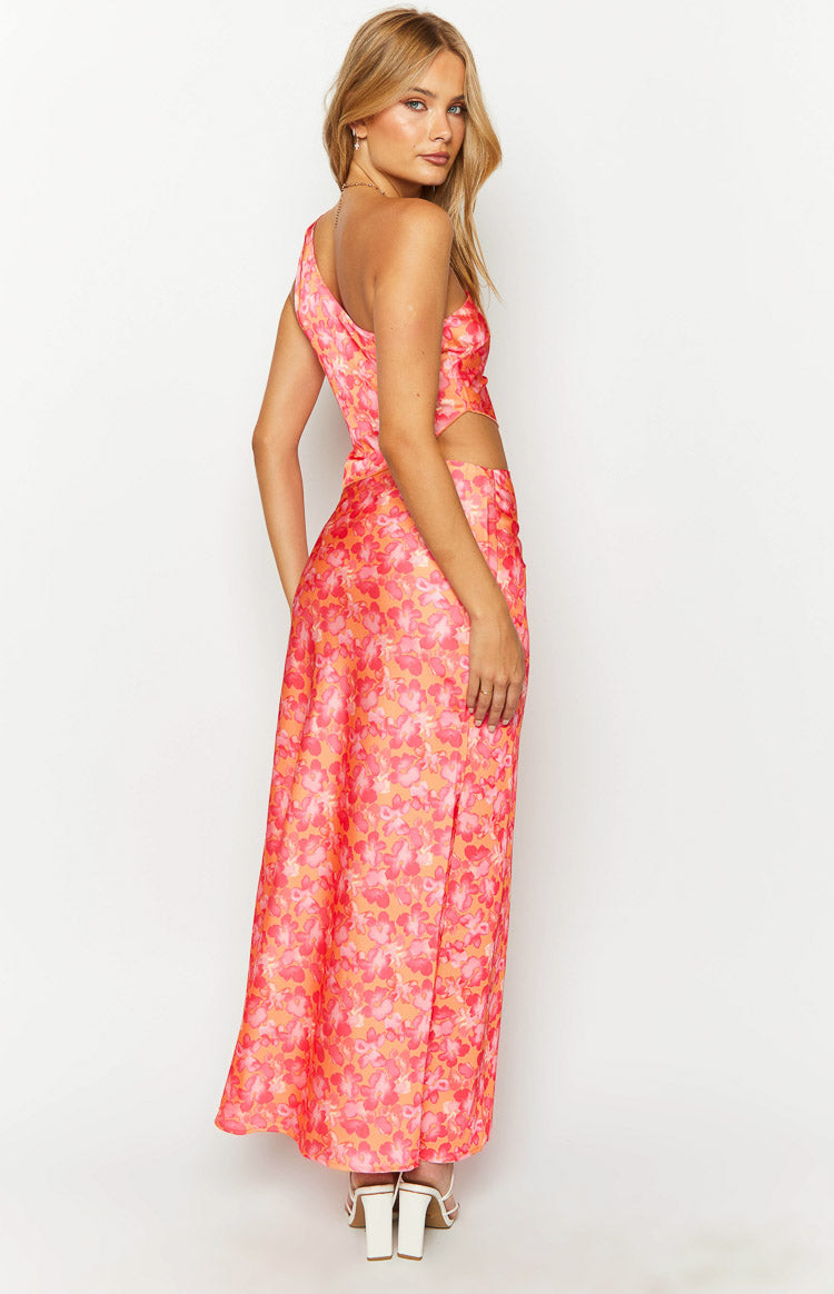 Side view of an orange and pink floral satin maxi skirt with a high side slit