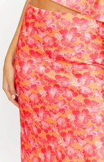 Close-up of the orange and pink floral print satin maxi skirt, showing the fabric's sheen and waist cutout
