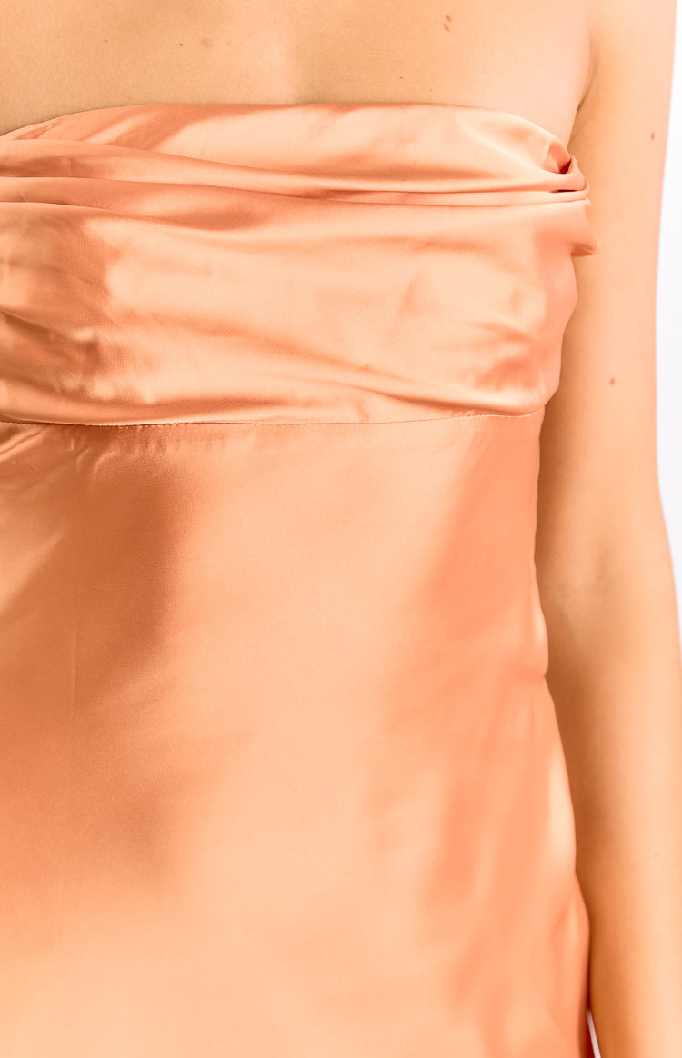 Close-up of the draped strapless neckline and smooth satin fabric of the orange mini dress