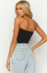Rear view of the black knit strapless corset top showing the ribbed texture and cropped hem