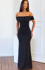 Full length view of a black polka dot mesh maxi dress with an off-shoulder ruched neckline