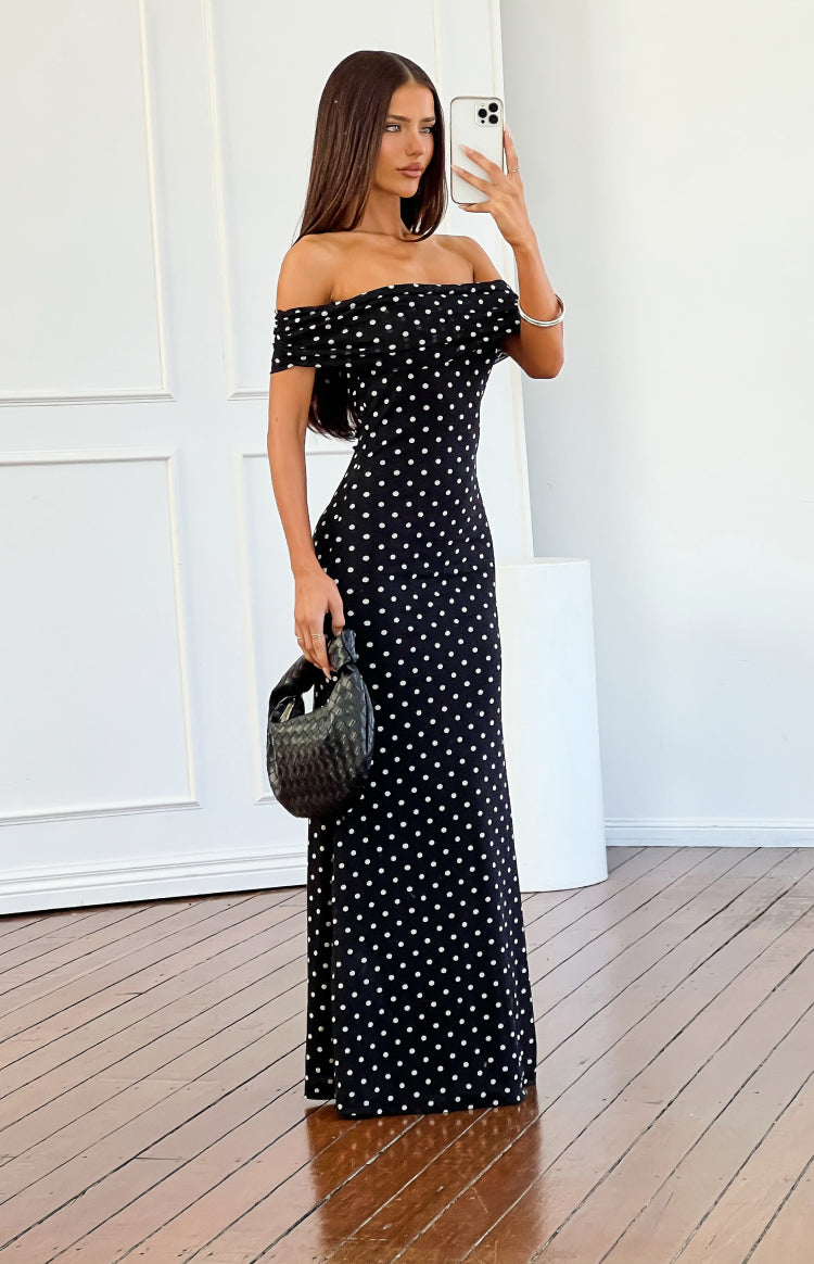 Side view of a black mesh maxi dress with white polka dots, off-shoulder ruched neckline, and short sleeves