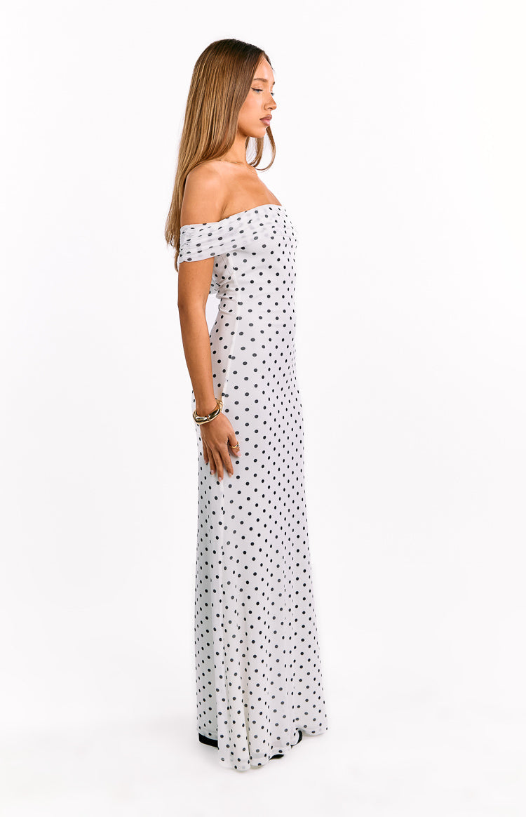 Side view showing the off-shoulder neckline and full length of the white polka dot mesh maxi dress