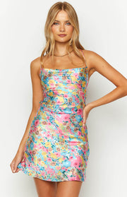 Close-up of the pink floral mini dress showing the square neckline, thin spaghetti straps, and ruched side detail